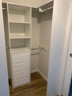 an empty closet with white drawers and shelves