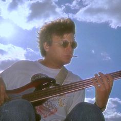 a man sitting on the ground playing a bass guitar