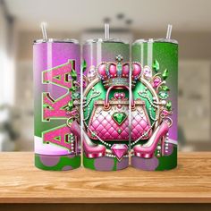 two pink and green canisters sitting on top of a wooden table next to each other