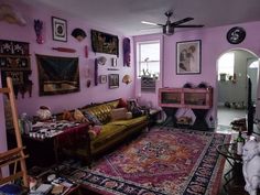 a living room filled with furniture and lots of pictures on the wall above an area rug