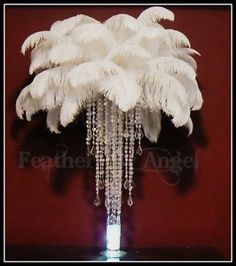 a vase filled with white feathers on top of a table