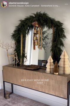 a mirror sitting on top of a wooden table next to a christmas wreath and other decorations