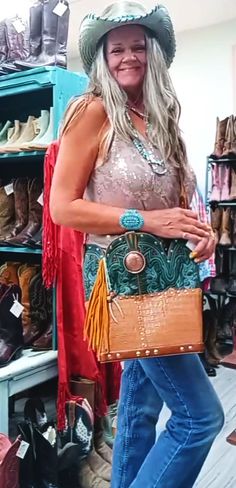 This cowboy boot purse is a must-have for the free-spirited fashionista who loves to infuse her look with a dose of Southwestern style. Made from a genuine pair of cowboy boots Tote style with no interior pockets Recycled leather belts used for the straps & trim Magnetic closure and western concho detail Dimensions: approximately 10"x14" Signed and numbered for exclusivity. Pair it with your favorite jeans and tee for a Santa Fe-chic look, or dress it up for a night out on the town. Either way, Leather Fringe Tote Shoulder Bag, Purse With Fringe, Totes Boots, Boot Purse, Best Cowboy Boots, Fringe Cowboy Boots, Western Purses And Handbags Cowgirl, Cowboy Boot Purse, Hipster Purse