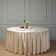 a round table with two plates on it and a vase filled with flowers in the middle