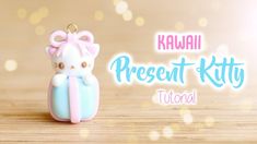 a small toy cat sitting on top of a wooden table with the words kawaii present kitty