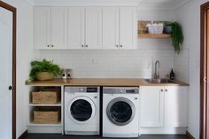 a kitchen with white cabinets and washer and dryer