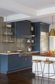 a kitchen with blue cabinets and wooden floors