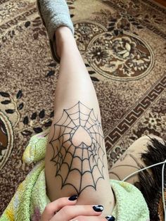 a woman's legs with a spider web tattoo on her left arm and leg