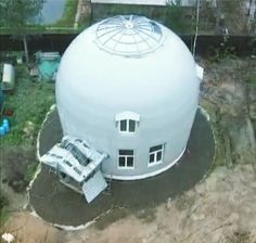 an aerial view of a large white building with two cars parked in front of it