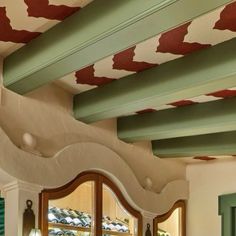 the interior of a house with green and red paint on the ceiling, windows and doors