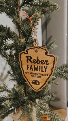 a wooden ornament hanging from a tree with the name reber family on it