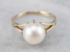 This pearl solitaire ring has a modernist style that is fresh and eye-catching! The pearl has a beautiful luster and warmth to it that is an excellent match to the luster of the 14 karat gold mounting. Architectural and sleek, this ring is well-designed! Metal: 14K Yellow Gold Gem: Pearl Gem Measurements: 8.2 mm, Round Ring Size: 5.50 Marks: "K14" Stamped on the inside band SKU #: MD9E9KKW Each piece has been identified and graded by a Graduate Gemologist who has been certified by the Gemologica Large Pearl Ring, Peal Rings, Dinner Rings, Pearl Ring Design, Pearl Birthstone, Ring Pearl, Colored Stone Rings, Pearl Necklace Designs, Gold Solitaire Ring