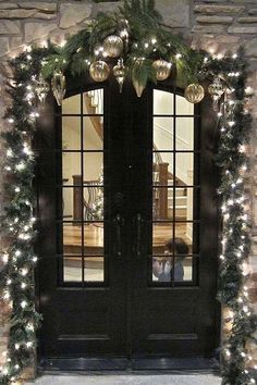 the front door is decorated for christmas with garlands and lights on it's sides