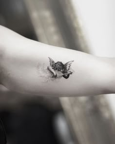 a black and white photo of a person's arm with a bird on it