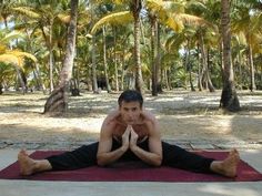 a man is doing yoga on a mat in the middle of palm trees and sand