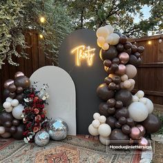 there is a large arch made out of balloons and some other decorations on the ground