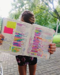 a person holding up a book with writing on it