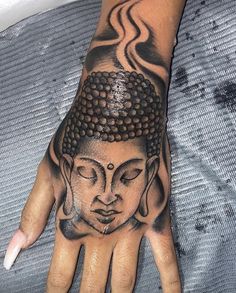 a person's hand with a tattoo on it and an image of a buddha head