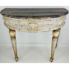 an old white and gold painted table on wheels