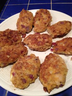 a white plate topped with meat patties on top of a blue tile floor