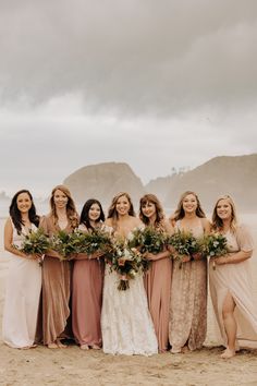 a group of women standing next to each other on a beach