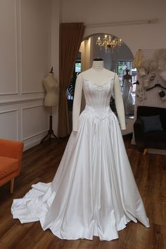 a white wedding dress on display in a room