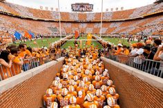 an orange and white football stadium filled with fans