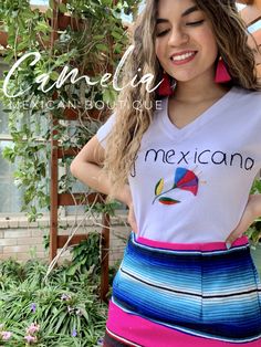 Mexican T-Shirt with Hand embroidered flower and phrase "Soy Mexicana". Made of cotton blend stretchable fabric. Sarape skirt sold separately. SIZE CHART: td {border: 1px solid #ccc;}br {mso-data-placement:same-cell;} MEXICAN T-SHIRT BUST LENGTH SMALL 34" 22.5" MEDIUM 36" 23" LARGE 41" 23" approximate measurements are in inches CARE: • Hand wash in cold water • Hang dry• Do not machine wash or dry. • Iron on low MADE IN OAXACA, MEXICO Please contact us if the item is out of stock to check availa Mexican Sarape, Hand Embroidered Flower, Mexican T Shirts, Mexican Blouse, Blouse Sale, Skirt Design, Skirts For Sale, Lead Time, Embroidered Flowers