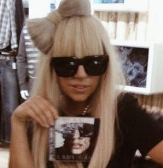 a woman with long blonde hair and cat ears holding up a book