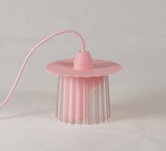 a pink light that is on top of a white tablecloth and has a cord attached to it