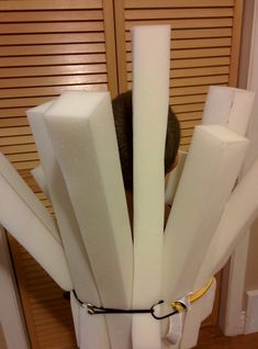 a person is hiding behind some white pieces of paper with their head between two poles