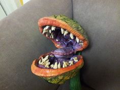 an odd looking toy on the back of a couch with it's mouth open