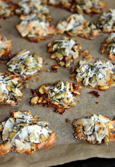 a baking sheet covered in cookies with nuts and cheese toppings on top, ready to go into the oven