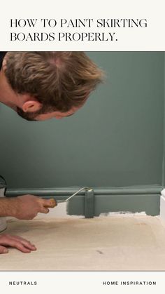 a man is painting the wall with white paint on it and has his hands in front of him