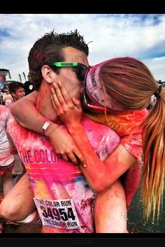 a man and woman hugging each other in the mud