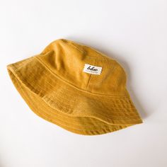 "The perfect bucket sun hat for women,men, babies and kids! Made from 100% cotton mustard yellow corduroy makes this hat very comfortable to wear. I made this hat with a day of adventure in mind, somewhere sunny and wild! This hat is made from a mustard yellow 100% cotton corduroy fabric. Inside liner is white cotton. Brim measures approx. 2.5\" wide. Crown measures approx. 3.5\" deep. Available in sizes: 0-3 mos. - 12\" to 14\" head circumference 3-6 mos. - 14\" to 16\" head circumference 6-12 Cheap Yellow Casual Sun Hat, Adjustable Yellow Cotton Hat, Yellow Brimmed Cotton Sun Hat, Yellow Cotton Brimmed Sun Hat, Yellow Cotton Beach Hat, Adjustable Corduroy Bucket Hat, Yellow Cotton Sun Hat, One Size Fits Most, Yellow Adjustable Cotton Bucket Hat, Yellow Cotton Sun Hat