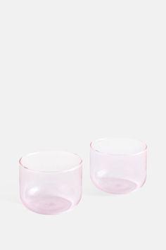 two pink glass bowls sitting next to each other