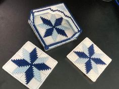 three blue and white coasters sitting on top of a black table next to a computer keyboard