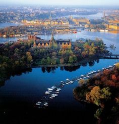 an aerial view of a city and its surrounding lake with boats on the water in front of it