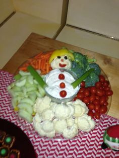 a plate full of vegetables with a snowman decoration on it