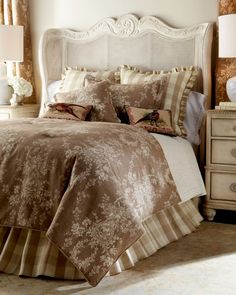 a bed with brown and white comforter in a bedroom next to two nightstands