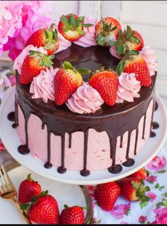 a chocolate cake topped with strawberries on top of a table