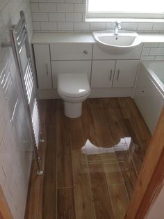 a white toilet sitting next to a sink in a bathroom