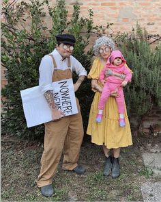 a man and woman dressed up in costumes holding a small child while standing next to each other