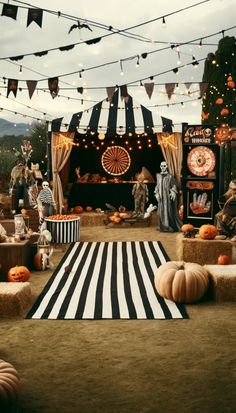 an outdoor halloween party with pumpkins, hay bales and decorations on the ground