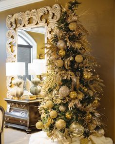 a decorated christmas tree in front of a mirror