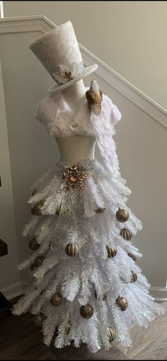 a dress made out of white feathers with a top hat