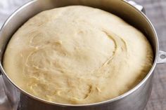 a metal pan filled with dough on top of a wooden table