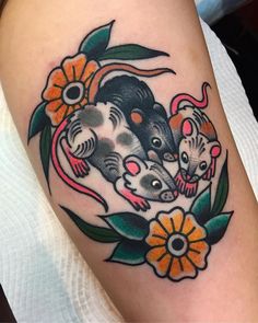 an image of a tattoo on the arm of a woman with flowers and two mice