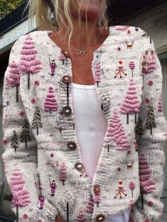 a woman wearing a white and pink cardigan sweater with trees on the front,